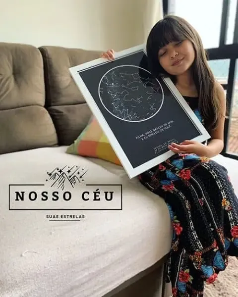 Menina com o mapa das estrelas do dia em que nasceu